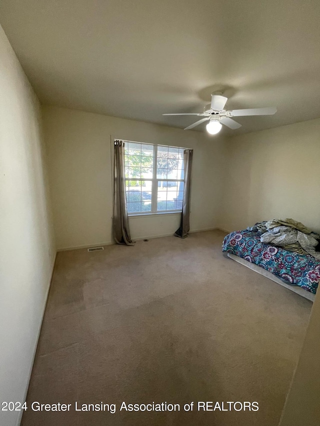 unfurnished bedroom featuring ceiling fan and carpet flooring