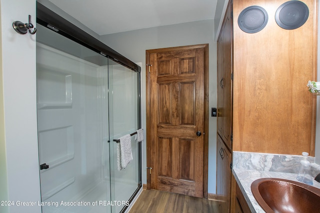 bathroom with hardwood / wood-style flooring, vanity, and an enclosed shower