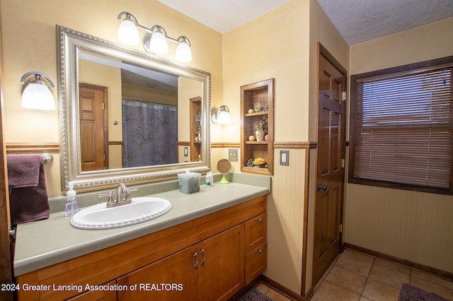 bathroom featuring tile patterned flooring, vanity, and a textured ceiling