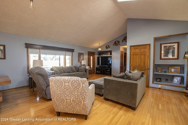 living room with a textured ceiling, high vaulted ceiling, and light hardwood / wood-style flooring