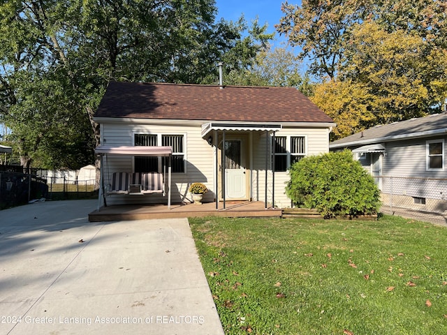 bungalow-style house with a deck and a front yard