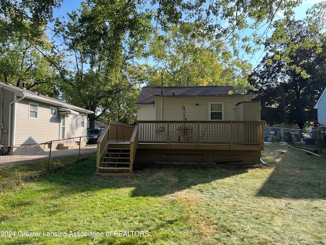 rear view of house with a lawn and a deck