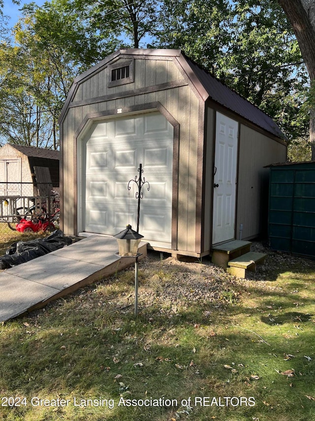 view of outdoor structure with a garage and a lawn