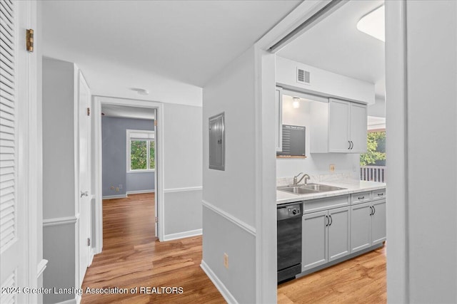 corridor featuring electric panel, sink, and light hardwood / wood-style flooring