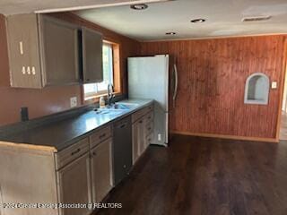 kitchen featuring wood walls, sink, dark hardwood / wood-style flooring, and white fridge