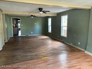 spare room featuring hardwood / wood-style floors, beam ceiling, and ceiling fan