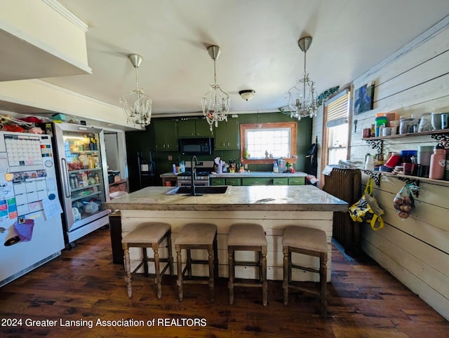 kitchen featuring white refrigerator, dark hardwood / wood-style floors, green cabinets, and a breakfast bar