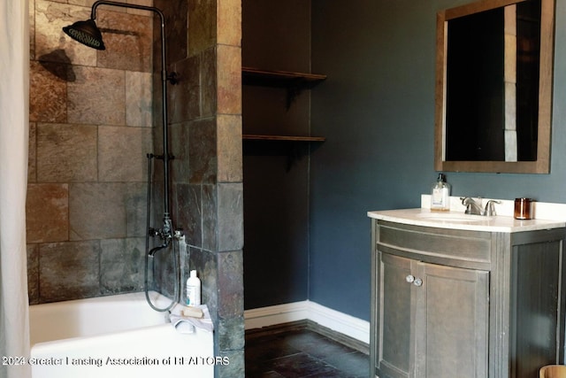 bathroom featuring tile patterned flooring, vanity, and tiled shower / bath combo