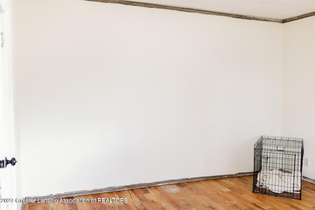 empty room featuring ornamental molding and hardwood / wood-style floors