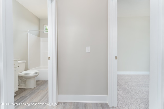 bathroom featuring toilet, baseboards, and shower / bathtub combination