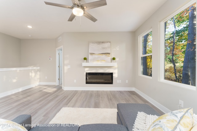 1534 Lytell Johnes Path # 76, Williamston, MI 48895 - living area with wood finished floors, a glass covered fireplace, a ceiling fan, baseboards, and recessed lighting