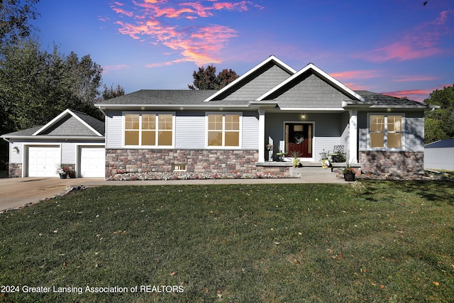 craftsman inspired home featuring an outdoor structure, a garage, and a yard