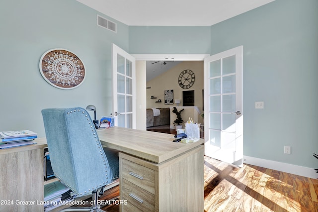 office with lofted ceiling, french doors, and dark hardwood / wood-style flooring