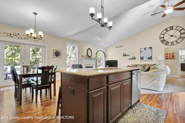 kitchen with hanging light fixtures, sink, a center island, vaulted ceiling, and dark hardwood / wood-style flooring