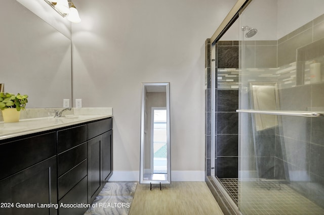 bathroom featuring walk in shower, vanity, and hardwood / wood-style flooring