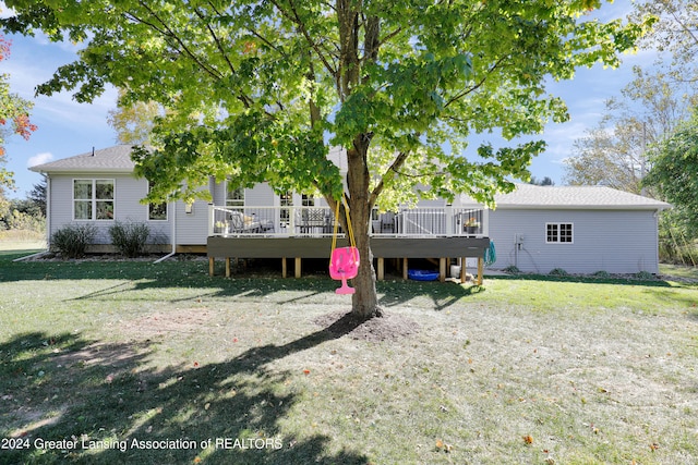 rear view of property with a wooden deck and a lawn