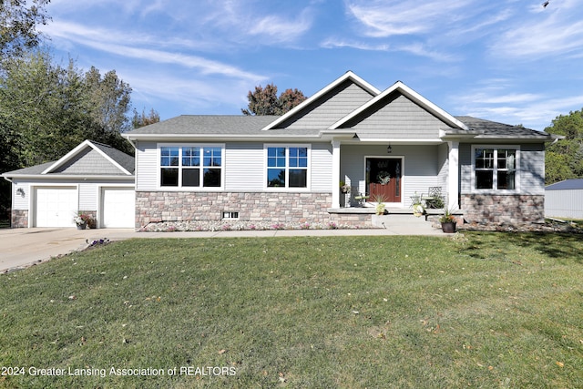 craftsman-style house with a front yard, an outdoor structure, and a garage