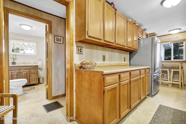 kitchen with plenty of natural light, stainless steel refrigerator, and sink