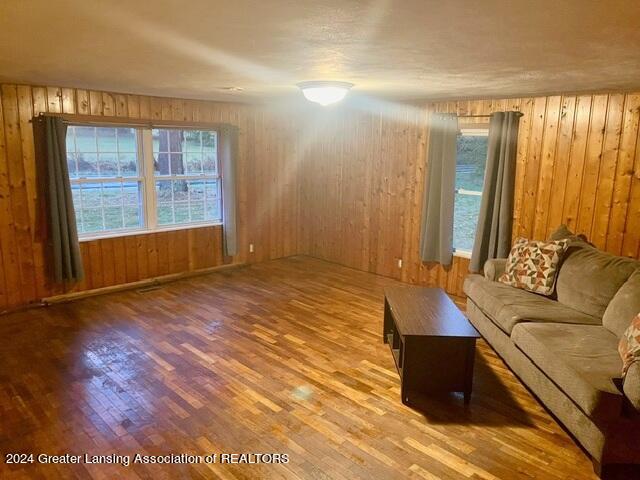 unfurnished living room with wood walls and light hardwood / wood-style floors