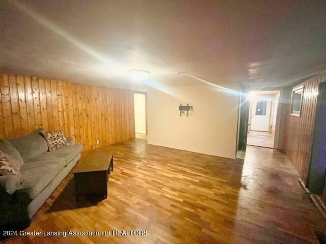 unfurnished living room featuring wood walls and hardwood / wood-style flooring