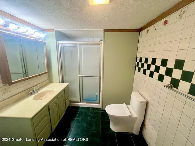 bathroom featuring vanity, a shower with shower door, toilet, and tile patterned flooring