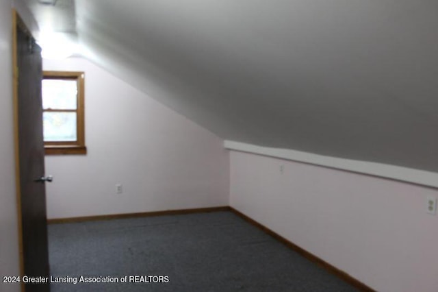 bonus room with lofted ceiling and carpet flooring