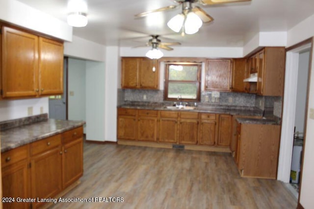 kitchen featuring ceiling fan, decorative backsplash, sink, and light hardwood / wood-style floors