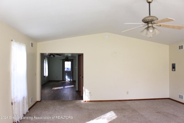 empty room featuring ceiling fan, lofted ceiling, a wealth of natural light, and hardwood / wood-style flooring