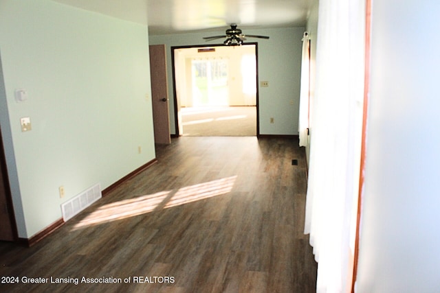 unfurnished room with ceiling fan and dark wood-type flooring