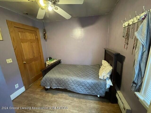 bedroom featuring a baseboard heating unit and ceiling fan