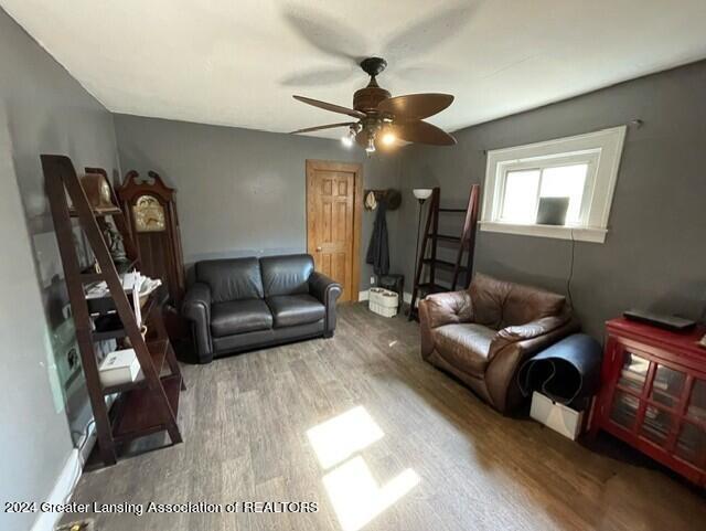 living room featuring wood-type flooring and ceiling fan