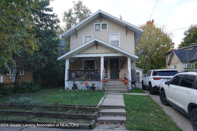 bungalow featuring covered porch and a front yard