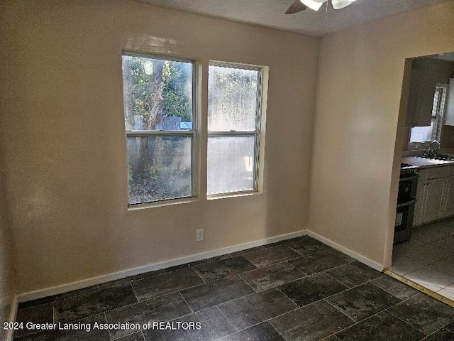 unfurnished dining area with sink and ceiling fan