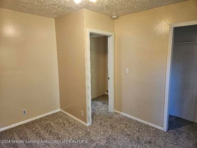 carpeted spare room with a textured ceiling