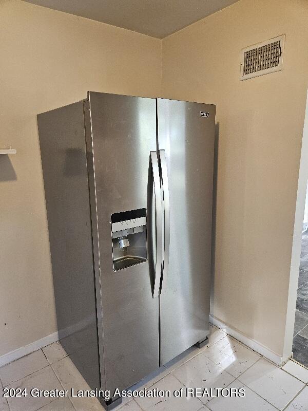 details with light tile patterned floors and stainless steel fridge with ice dispenser