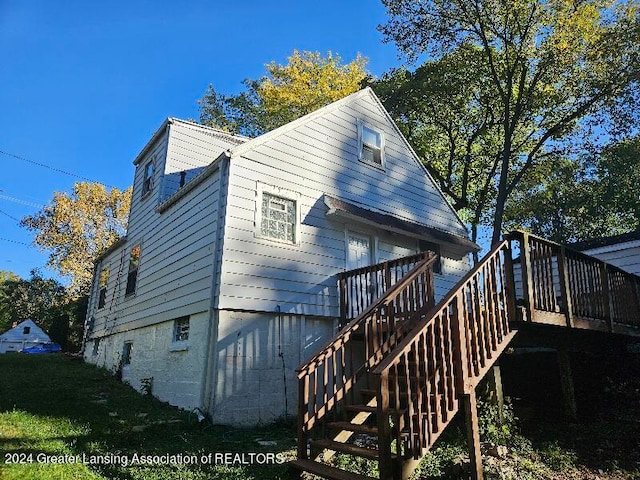 rear view of property featuring a wooden deck