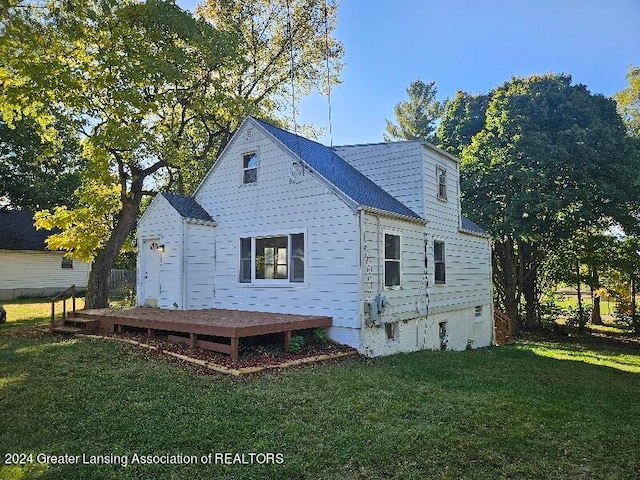 back of house featuring a wooden deck and a lawn