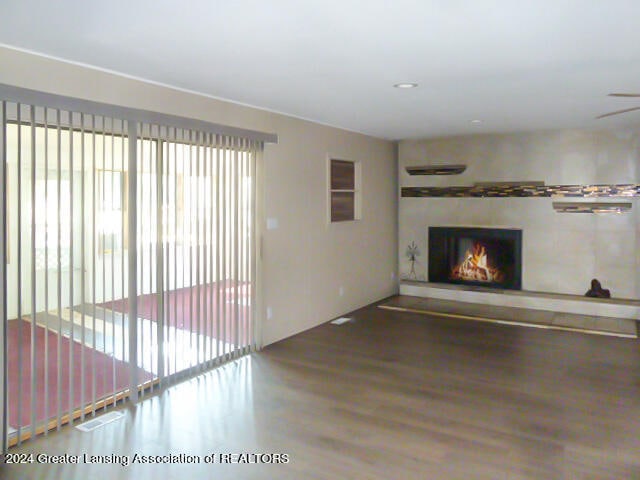 unfurnished living room featuring hardwood / wood-style floors and ceiling fan