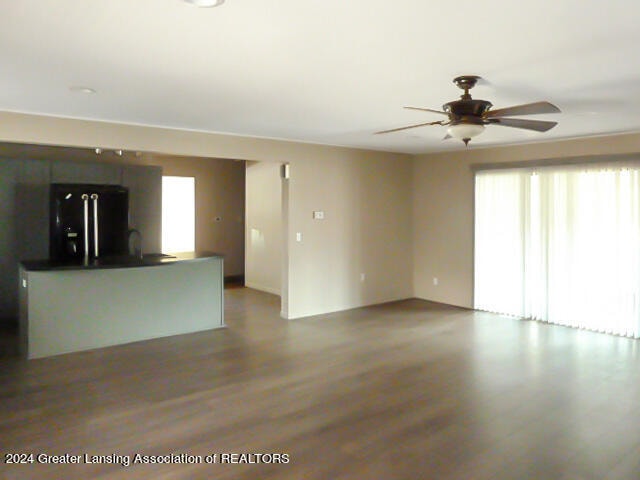 unfurnished living room featuring hardwood / wood-style floors and ceiling fan