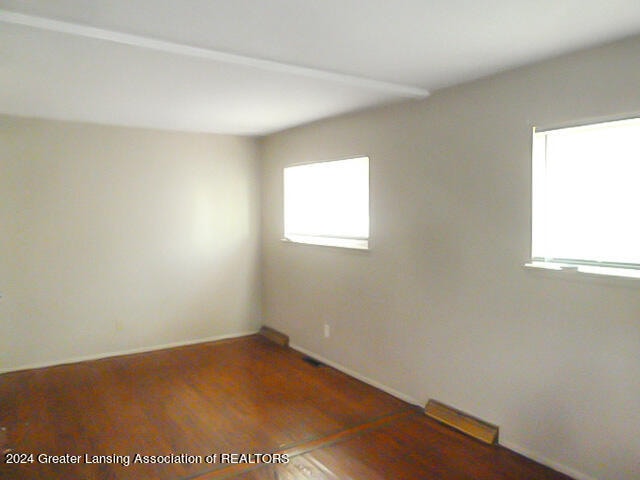 empty room with dark wood-type flooring