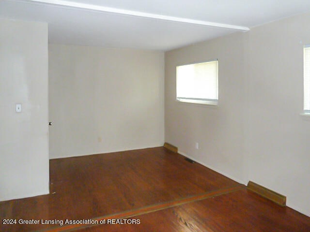 unfurnished room with dark hardwood / wood-style flooring