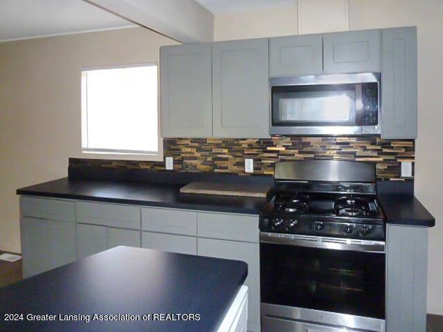 kitchen featuring stainless steel appliances and tasteful backsplash