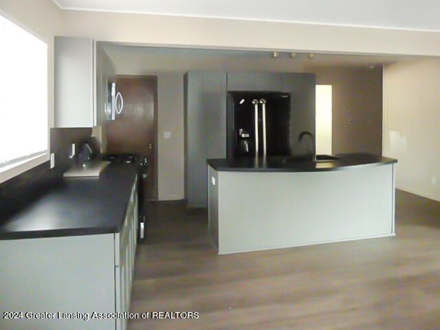 kitchen with light hardwood / wood-style flooring, white cabinetry, and black fridge