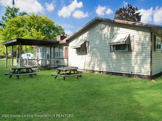 back of property featuring a lawn and a fire pit