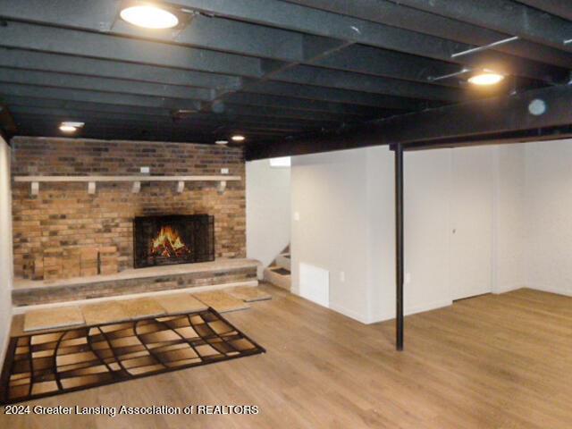 basement with hardwood / wood-style floors and a fireplace