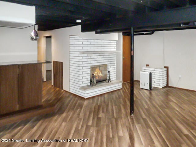 basement with hardwood / wood-style flooring and a brick fireplace