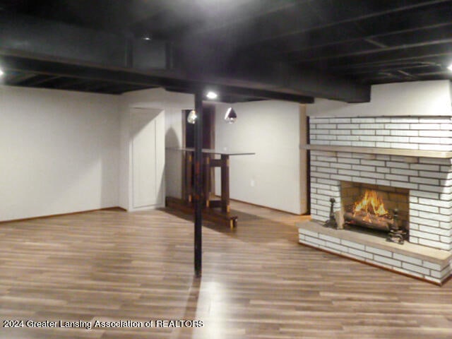 basement with hardwood / wood-style floors and a fireplace