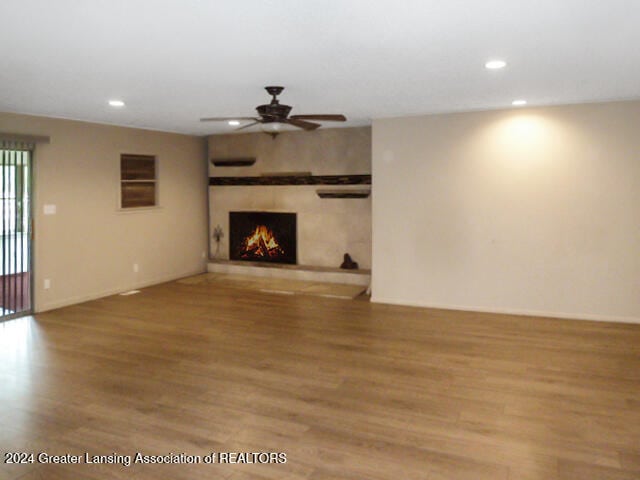 unfurnished living room with hardwood / wood-style flooring and ceiling fan