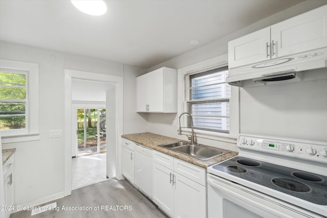 kitchen featuring white appliances, a healthy amount of sunlight, light hardwood / wood-style flooring, and white cabinets