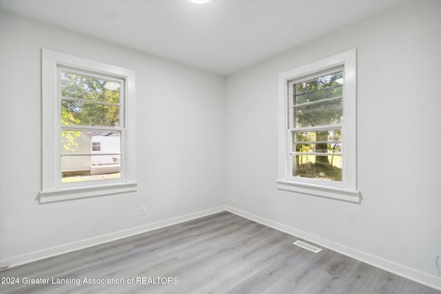 empty room with light hardwood / wood-style floors and a wealth of natural light